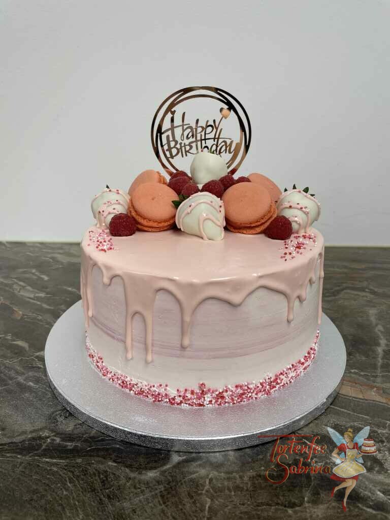 Geburtstagstorte Erwachsene - Erdbeer-Drip-Cake ist eine rosa farbene Torte mit vielen Süßigkeiten und Früchten oben drauf.