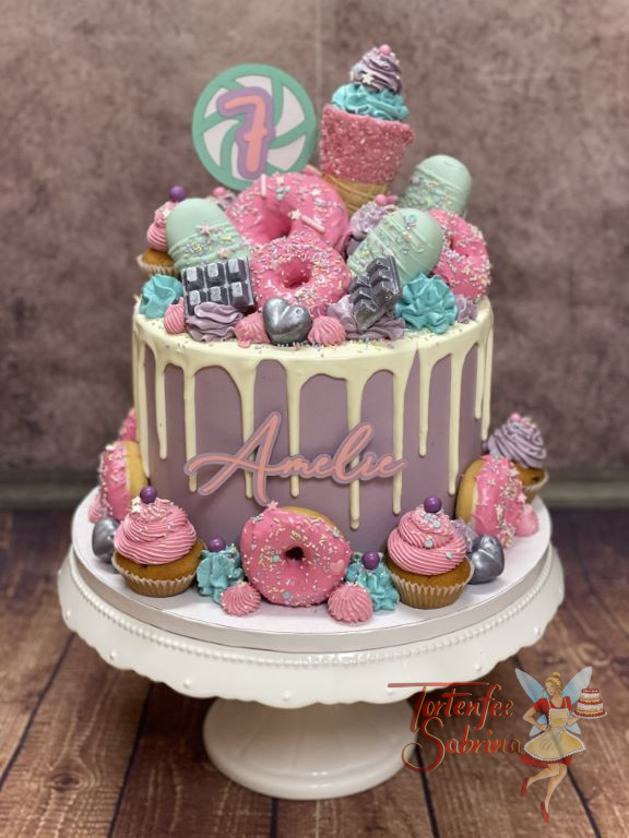 Geburtstorte Mädchen - Farbenfrohe Süßigkeiten sind bei dieser violetten Torte der Blickfang, vorne ist der Name angebracht.