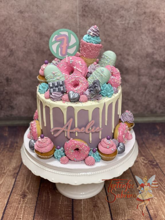 Geburtstorte Mädchen - Farbenfrohe Süßigkeiten sind bei dieser violetten Torte der Blickfang, vorne ist der Name angebracht.