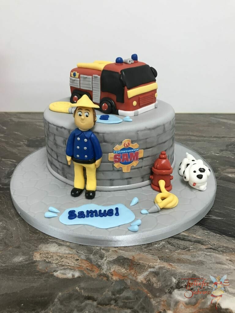 Geburtstagstorte - Feuerwehrmann Sam mit Jupiter auf ein grauen Torte mit Steinmuster, und der rote Hydrant darf auch nicht fehlen.