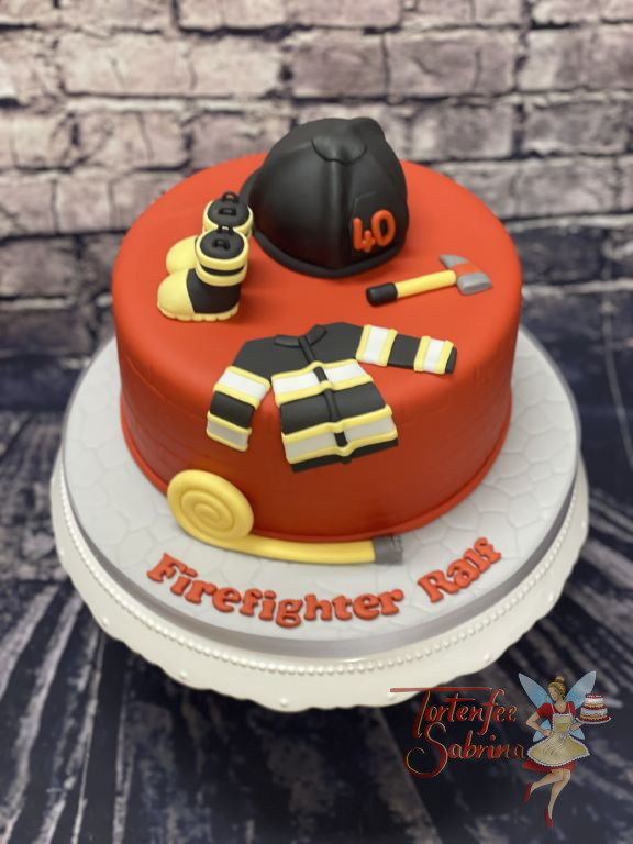 Geburtstagstorte Erwachsene - Feuerwehrstiefel, Feuerwehrjacke und Feuerwehrhelm zieren diese ganz rote Torte.