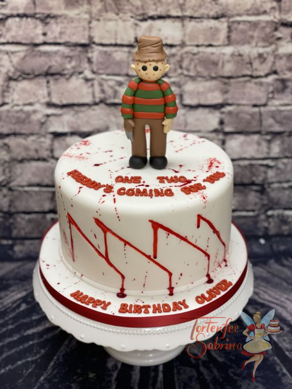 Geburtstagstorte Erwachsene - Freddy Krueger von dem Film Nightmare on Elm Street ist ganz oben auf der Torte umgeben von roten Spritzern.