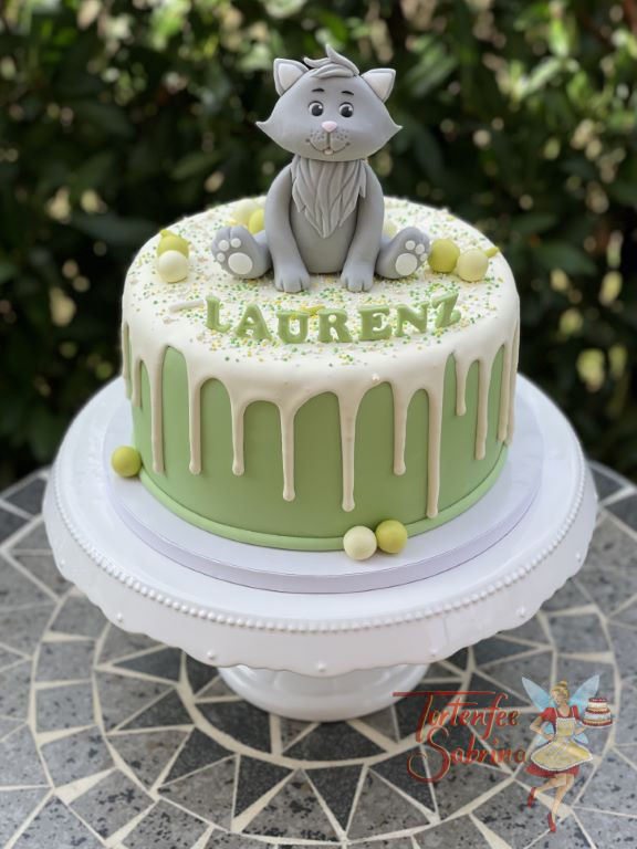 Geburtstagstorte Buben - Fröhliche Katze sitzt ganz oben auf dem weiß und grünen Drip Cake und spitzt die kleine Ohren.