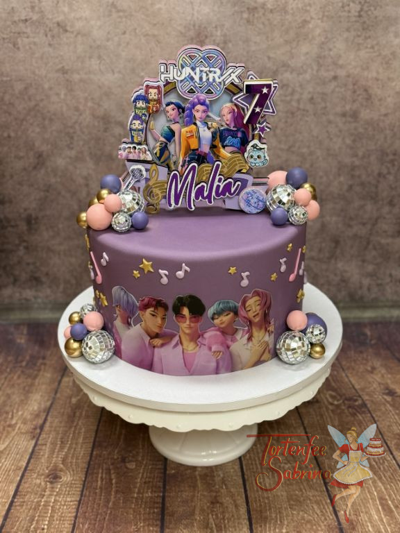 Geburtstagstorte Mädchen - Girlband Huntrix wird durch einen Caketopper auf der Torte dargestellt, umgeben von Discokugeln.