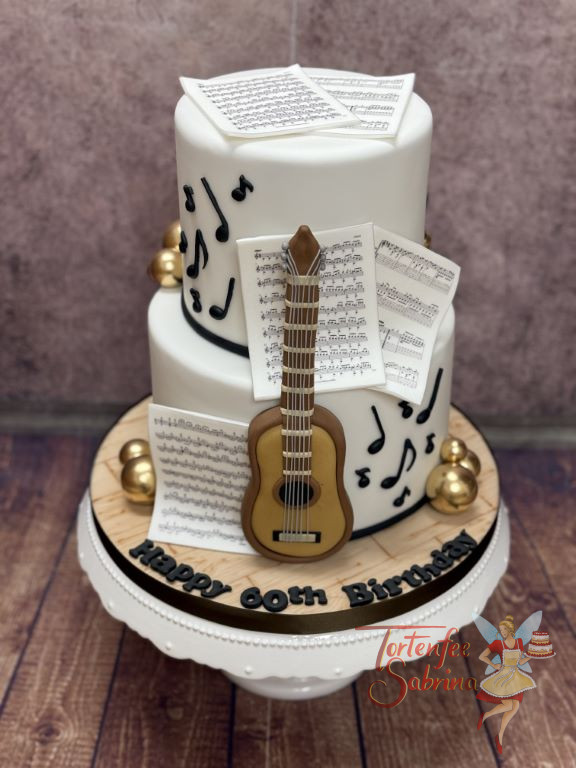 Geburtstagstorte Erwachsene - Gitarre und Noten verzieren die zweistöckige weiße Torte für den leidenschaftlichen Musiker.
