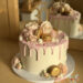 Geburtstagstorte Erwachsene - Goldener 30er in Form des Caketoppers ist umgeben von zarten rosa Rosen und goldenen Macarons.