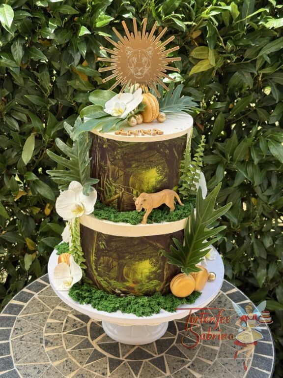 Geburtstagstorte Erwachsene - Goldener Löwe ist oben als Caketopper zu sehen, tropische Blätter und Blüten zieren seitlich die Torte.