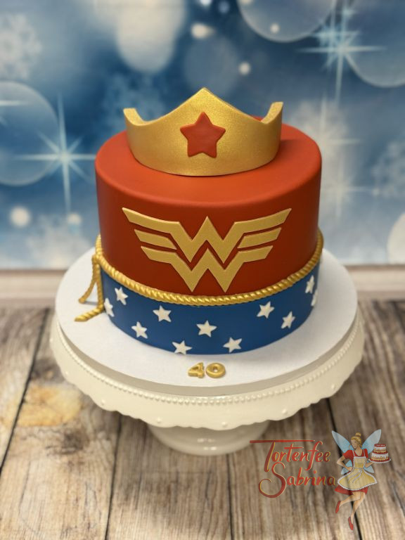 Geburtstagstorte Erwachsene - Goldenes W von Wonderwoman ziert vorne neben dem Sternenmuster die rot-blaue Torte.