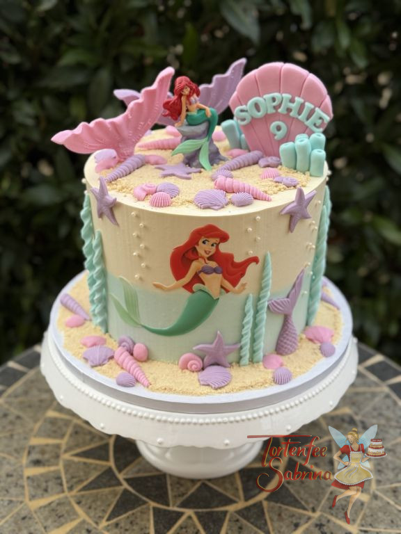Geburtstagstorte Mädchen - Große rosa Muschel ist oben auf der Torte zu sehen, Arielle die Meerjungfrau ist auch vorne abgebildet.