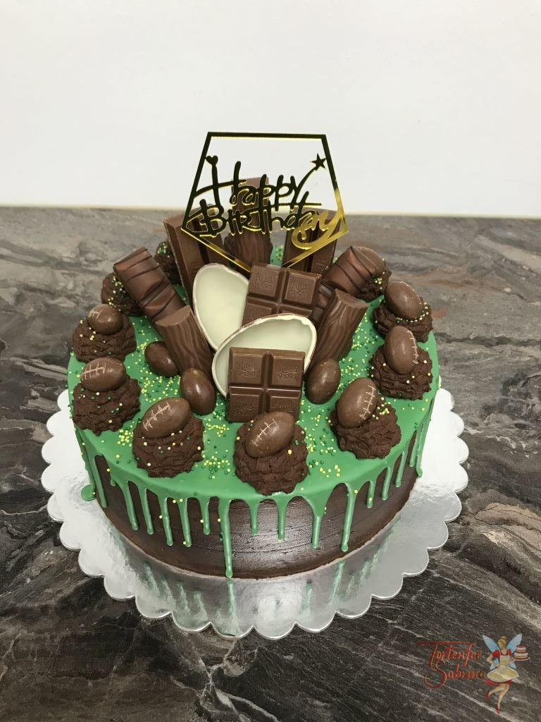 Geburtstagstorte Erwachsene - Grüner Drip mit Süßem. Hier wurde die Torte mit vielen verschiedenen Süßigkeiten und Mini-Footbällen verziert.
