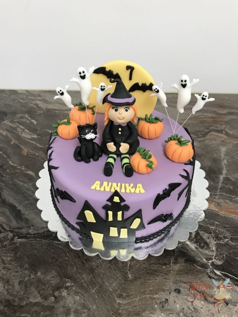 Geburtstagstorte Mädchen - Halloween mit Hexe und Geisterhaus. Ebenso auf der Torte sind Kürbise, Geister und eine schwarze Katze.