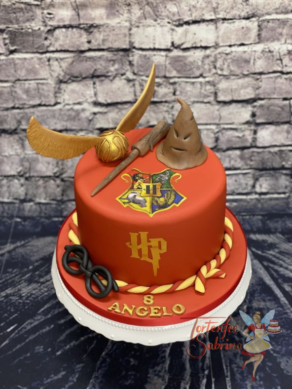 Geburtstagstorte Buben - Hogwarts Wappen in der Mitte auf der Torte über Harrys Initialien. Mitdabei ist der goldene Schnatz.