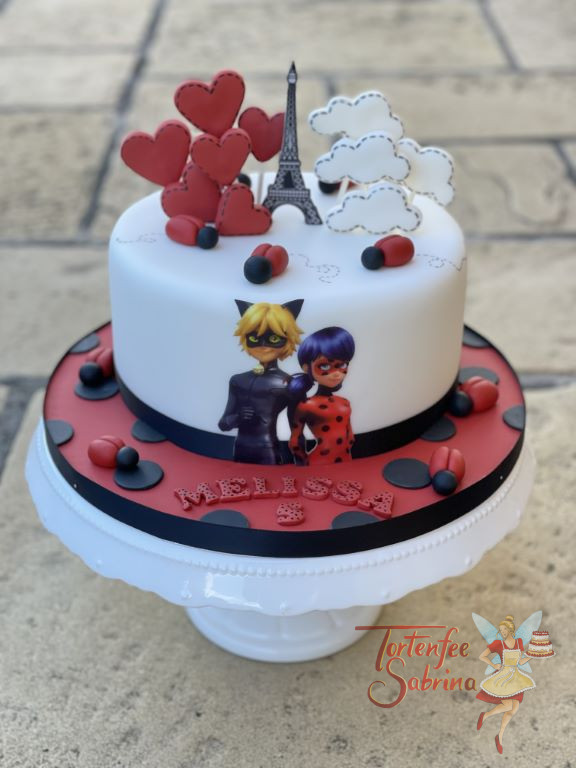 Geburtstagstorte Mädchen - In Paris sind Ladybug und Cat Noir gemeinsam, denn ganz oben auf der Torte seht ein kleiner Eiffelturm.