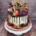 Geburtstagstorte Erwachsene - Kleine Trompete in Form des Caketoppers verziert neben Früchten und Süßigkeiten die Torte.