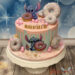 Geburtstagstorte Mädchen - Kleiner blauer Stitch sitzt oben auf der Torte und verschlingt die bunten Donuts mit Streusel.
