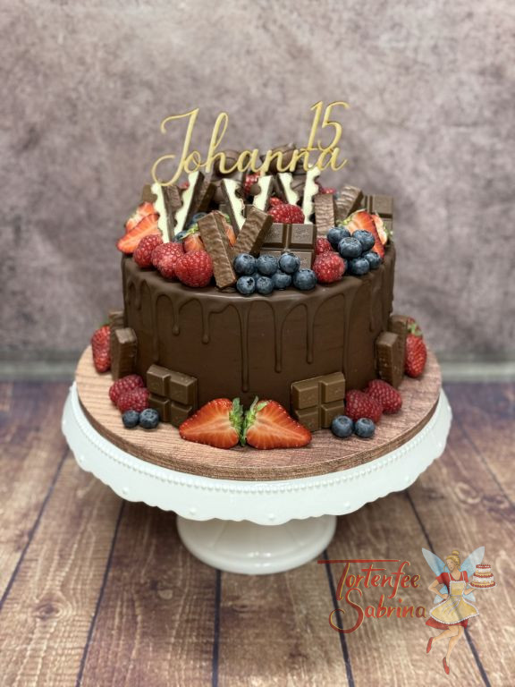 Geburtstagstorte Mädchen - Leckere Kinderriegel und andere Süßigkeiten verzieren neben dem Caketopper die Torte.