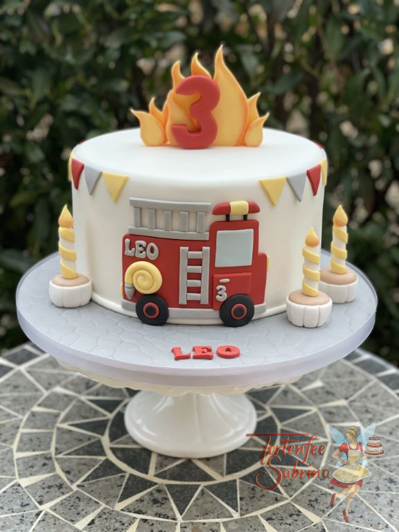 Geburtstagstorte Buben - Leos Feuerwehrauto ist vorne auf der Torte abgebildet und oben zieren Flammen diese.