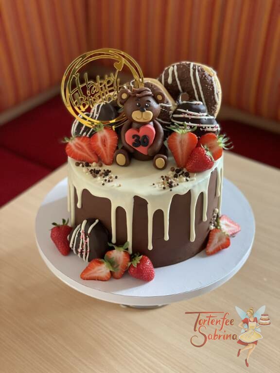 Geburtstagstorte Erwachsene - Marzipanbärchen auf dem Drip Cake welcher mit Süßigkeiten, Früchten und einem Cake-Topper verziert ist.