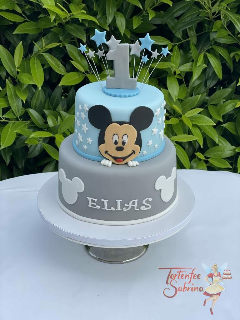 Geburtstagstorte Buben - Mickey mit blauen und grauen Sterne und einer ganz großen 1 oben. Die Torte wurde in den Farben blau und grau eingedeckt.