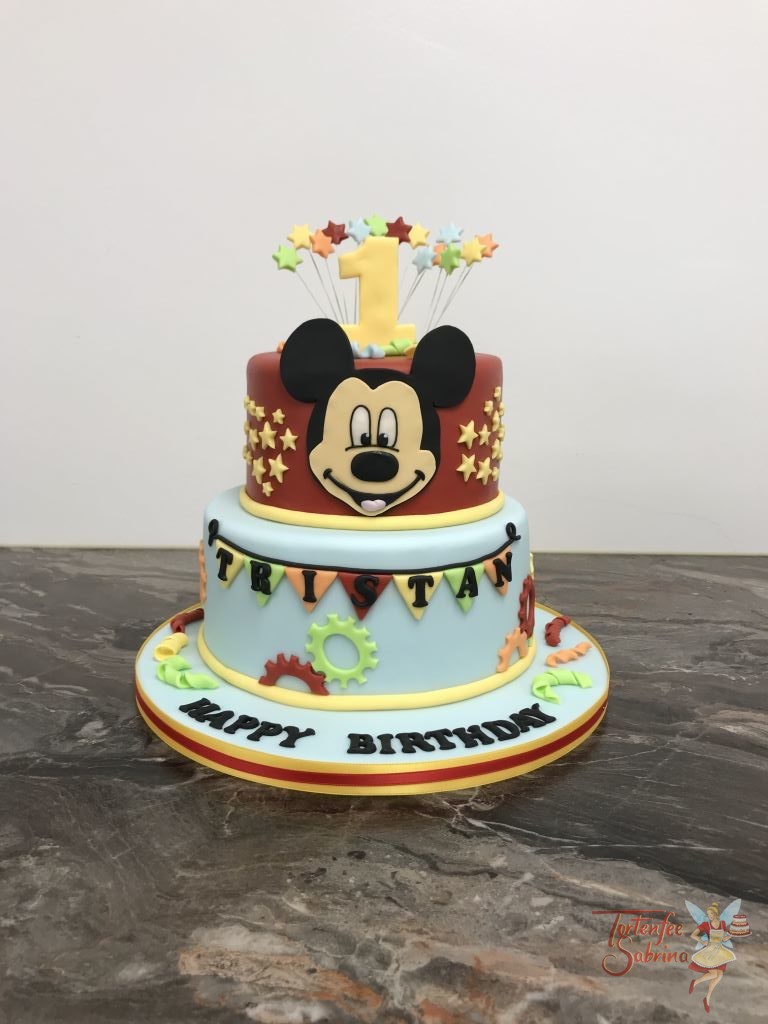 Geburtstagstorte Buben - Mickey Mouse and Stars. Die Torte ist verziert mit Sternen und Zahnrädern in den Farben rot, blau, orange und grün.