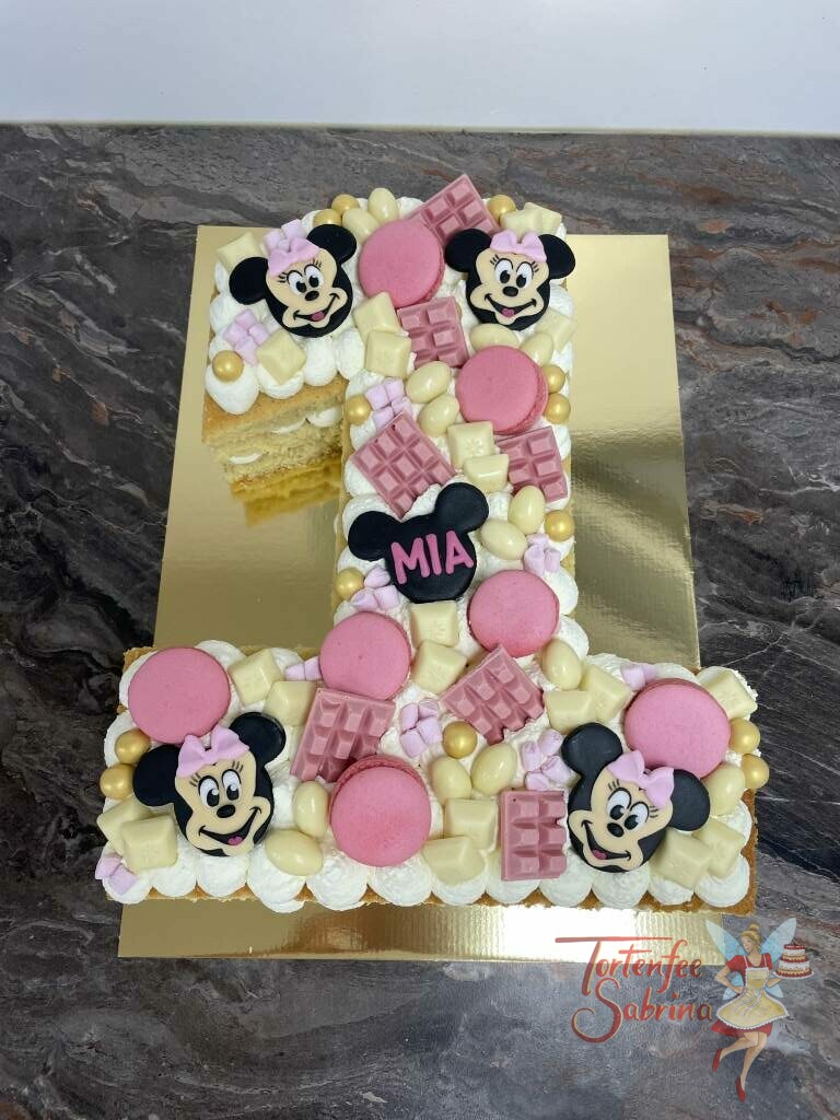 Geburtstagstorte Mädchen - Minnie Mouse auf der 1, verziert mit vielen verschiedenen Süßigkeiten und Macronen, sowie Minnie Mouse Gesichter.
