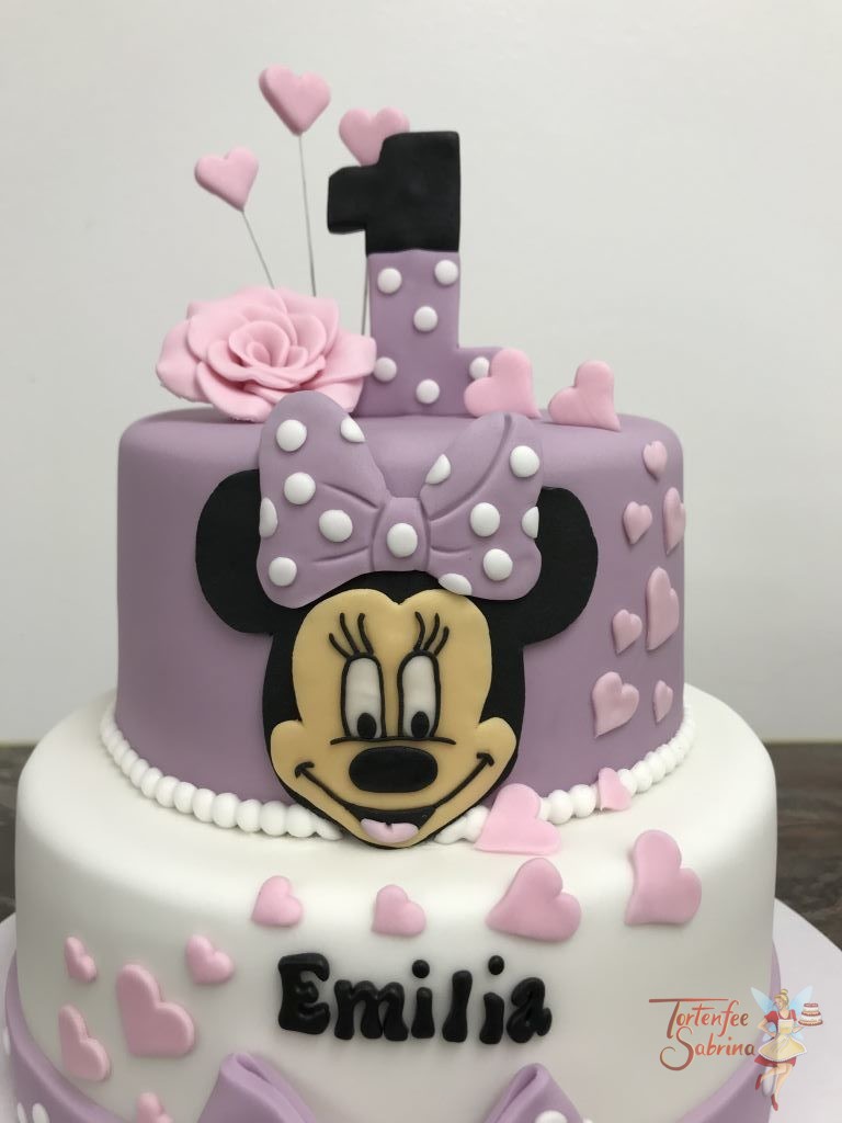 Geburtstagstorte - Minnie Mouse in lila. Verziert mit lila Schleifen, rosa Herzen und einer zweifärbigen 1.