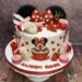 Geburtstagstorte Mädchen - Minnie Mouse in Rot mit Schleife ist umgeben von vielen roten Herzen und goldenem Caketopper.