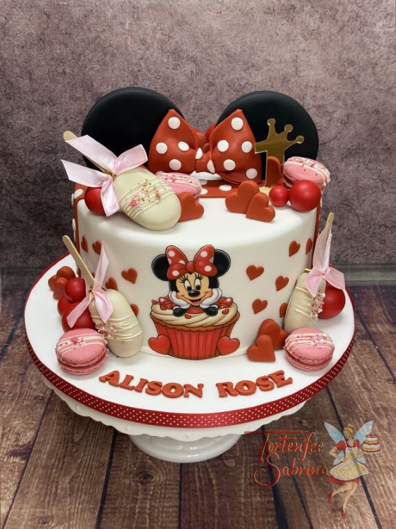 Geburtstagstorte Mädchen - Minnie Mouse in Rot mit Schleife ist umgeben von vielen roten Herzen und goldenem Caketopper.