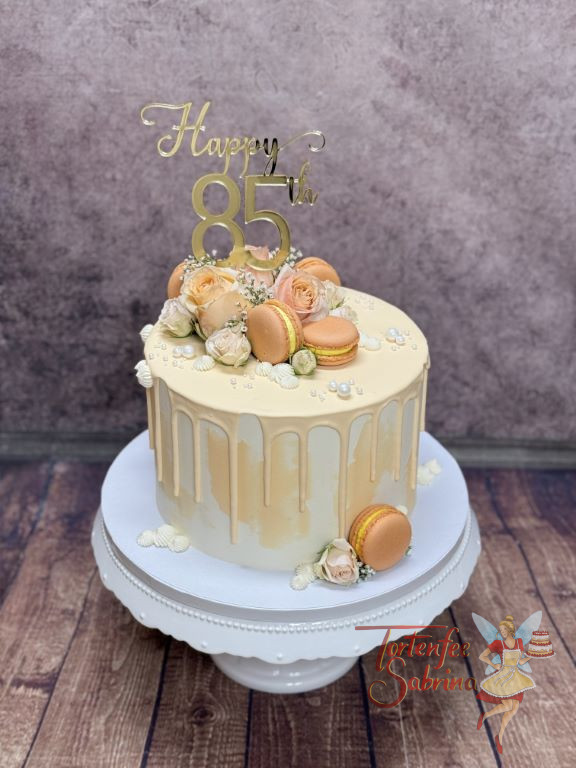 Geburtstagstorte Erwachsene - Orange Macarons verzieren auf dem aprikofarbenem Drip die Torte mit goldenem Caketopper.