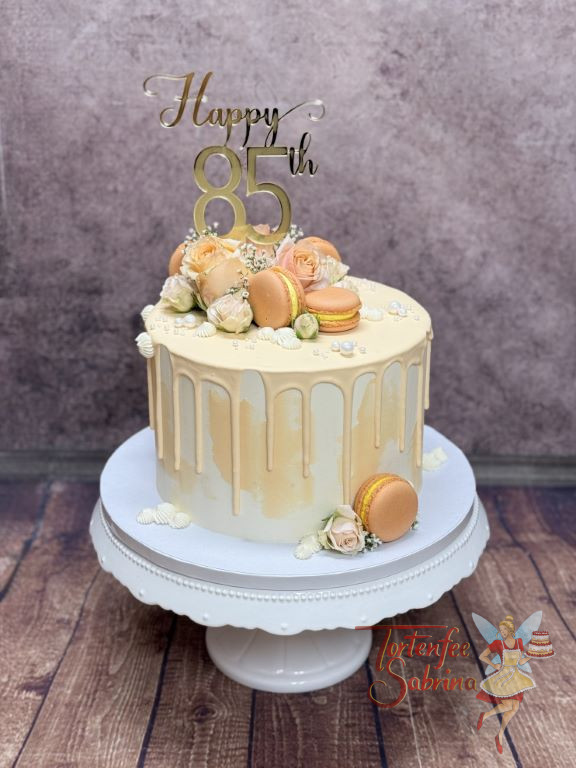 Geburtstagstorte Erwachsene - Orange Macarons verzieren auf dem aprikofarbenem Drip die Torte mit goldenem Caketopper.