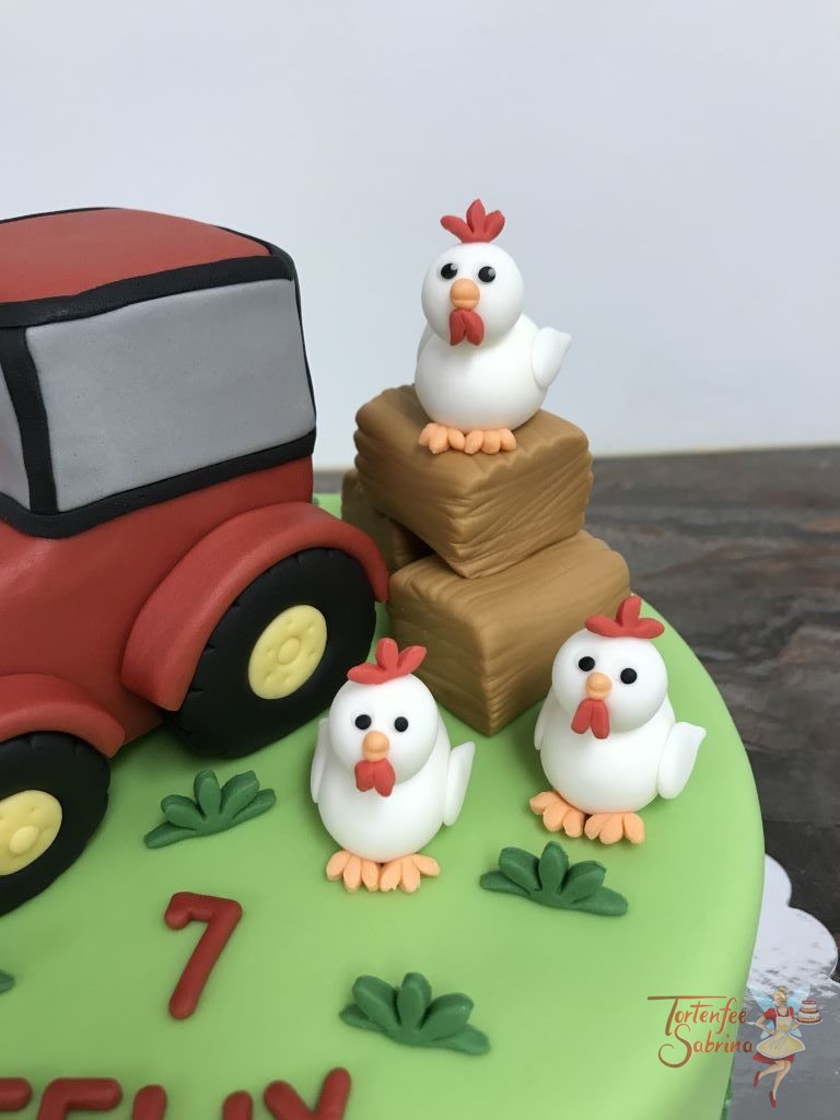 Geburtstagstorte Buben - Pipihendl mit Traktor. Drei Hühner sitzen in der Wiese und auf Strohpinkerl bei ihrem roten Traktor.