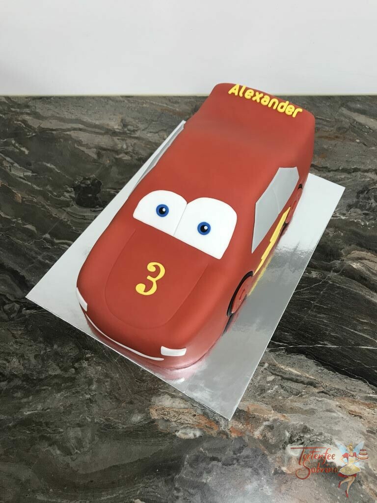 Geburtstagstorte Buben - Red Lightning McQueen, steht und glänz in seiner schönen roten Farben mit gelbem Blitz.