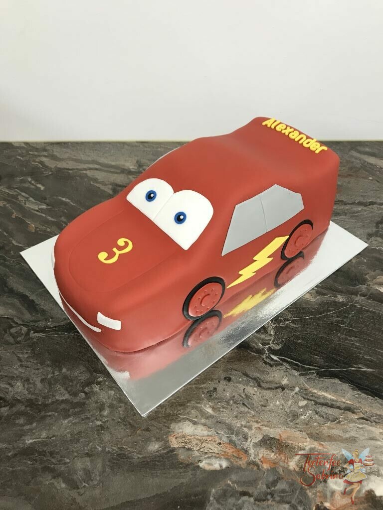 Geburtstagstorte Buben - Red Lightning McQueen, steht und glänz in seiner schönen roten Farben mit gelbem Blitz.
