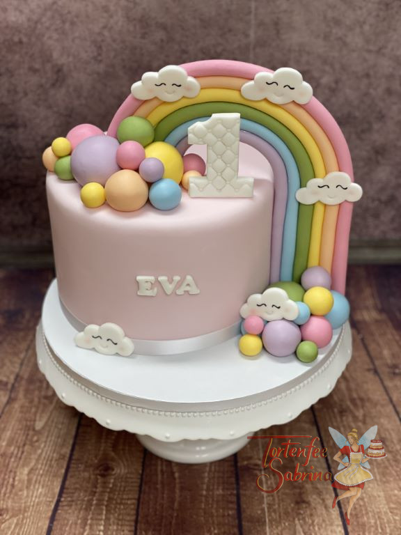 Geburtstagstorte Mädchen - Regenbogen und Wolken zieren neben bunten Kugeln und einer weißen 1 mit Muster die Torte.
