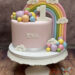 Geburtstagstorte Mädchen - Regenbogen und Wolken zieren neben bunten Kugeln und einer weißen 1 mit Muster die Torte.