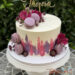 Geburtstagstorte Mädchen - Rosa Blumen treffen auf lila Macarons. Oben ziert ein personalisierter Caketopper die Torte.