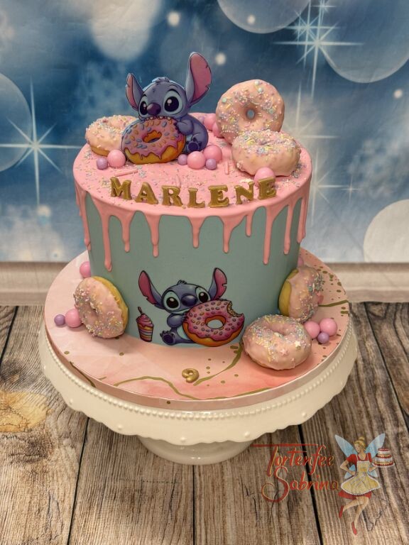 Geburtstagstorte Mädchen - Rosa Drip mit Stitch welcher sich über die unzähligen bunten Donuts auf der Torte.