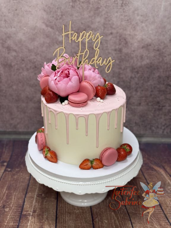 Geburtstagstorte Erwachsene - Rosa Pfingstrosen auf einem rosa Drip verzieren neben Erdbeeren und Macarons die Torte.