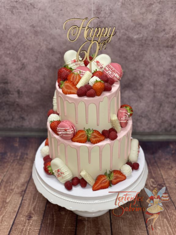 Geburtstagstorte Erwachsene - Rosa Süßigkeiten zieren neben roten Beeren die zweistöckige Torte mit Caketopper.