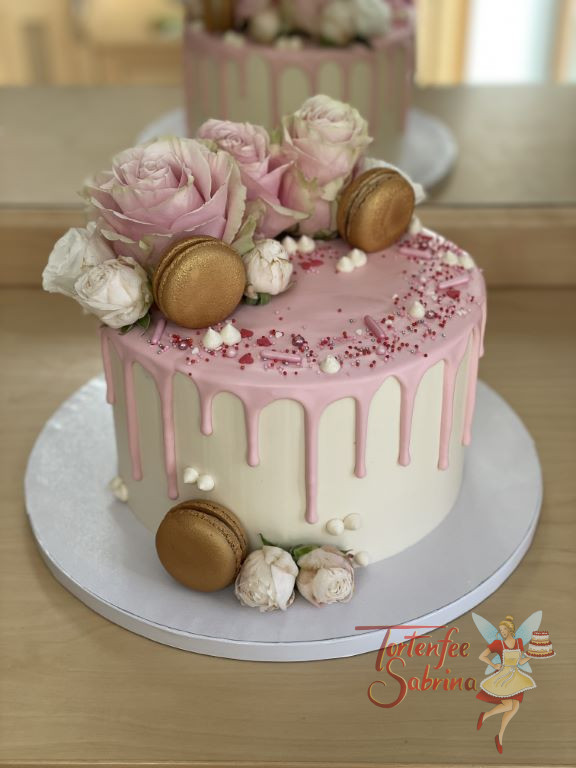 Geburtstagstorte Erwachsene - Rosa und Gold verzieren die Torte, ein rosafarbener Drip und goldene Macarons.
