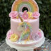 Geburtstagstorte Mädchen - Rosen für das Einhorn zieren oben und unten die Torte, ebenfalls auf der Torte ist ein Regenbogen.