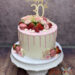Geburtstagstorte Erwachsene - Rote Erdbeeren und Himbeeren verzieren neben den rosa Drip und dem Caketopper die Torte.