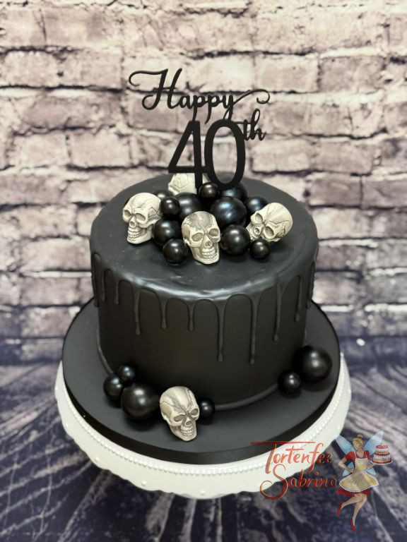 Geburtstagstorte Erwachsene - Schwarz auf schwarz, hier zieren kleine Totenköpfe und schwarze Kugeln den Drip Cake.