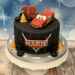 Geburtstagstorte Erwachsene - Schwarzer Reifen liegt als Torte auf der Platte, oben ziert der rote Lightning McQueen die Torte.