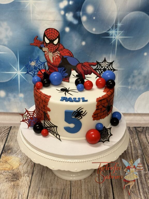Geburtstagstorte Buben - Spidermans Netze in verschiedenen Farben verzieren die Torte neben dem Superhelden.