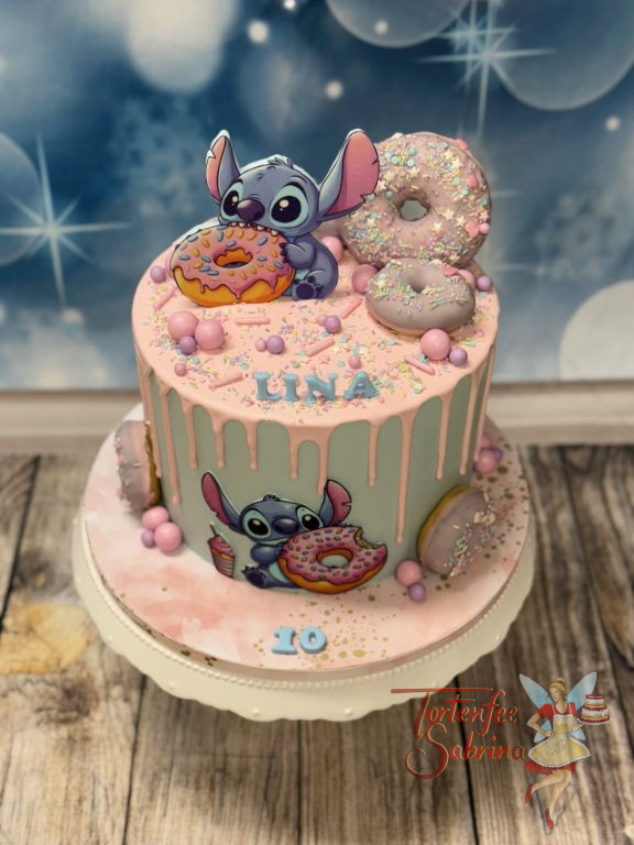 Geburtstagstorte Mädchen - Stitch und die bunten Donuts zieren die Torte neben dem zarten rosa Drip aus Schokolade.