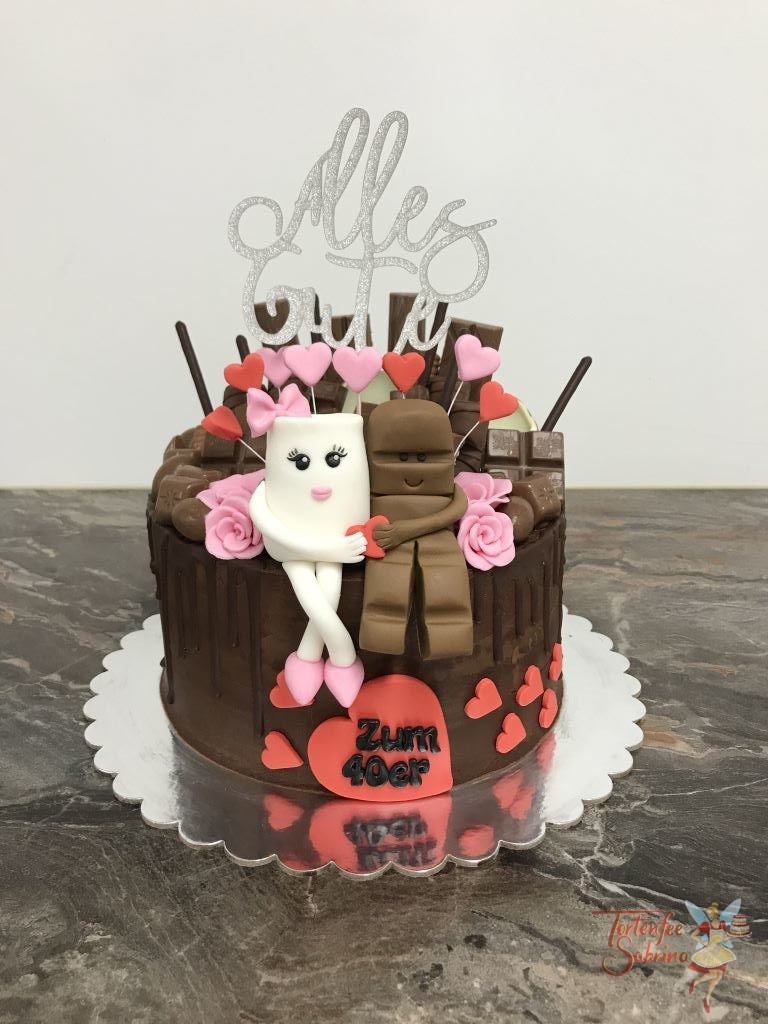 Geburtstagstorte Erwachsene - Süßer Schokoriegel mit Milchglass und vielen verschiedenen Süßigkeiten. Ebenso wurde die Torte mit Herzen und Blumen verziert.