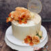 Geburtstagstorte Erwachsene - Traumhafte Aprikotöne in Form des Drips und der Blumen zieren die Torte, mit dabei ein goldener Caketopper.