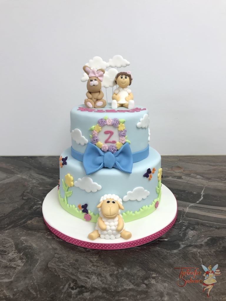 Geburtstagstorte Mädchen - Valerie mit Hase und Schaf. Die Torte wurde noch mit einer blauen Schleife, Wolken und vielen bunten Blumen.
