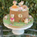 Geburtstagstorte Mädchen - Vier fröhliche Waldtiere sitzen auf und neben dem Baumstamm, mit auf der Torte Fuchs, Reh, Eule und Igel.